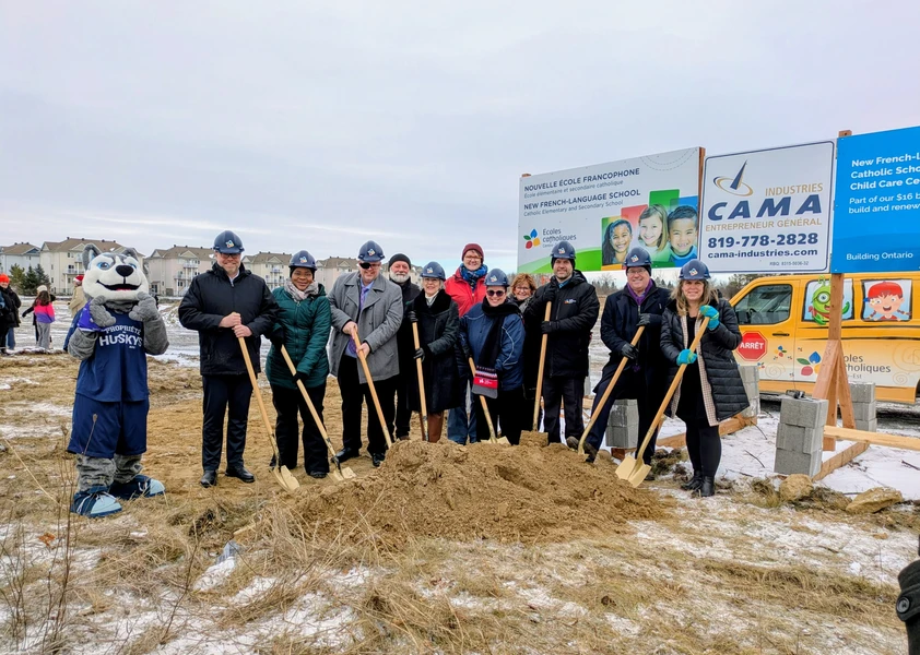 Des représentants du CECCE et des représentants politiques prennent la pose pour la pelletée de terre officielle. Ils portent un casque de construction et tiennent du pelle.